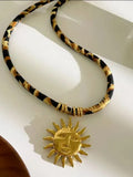 Cadena en tela con dije de sol